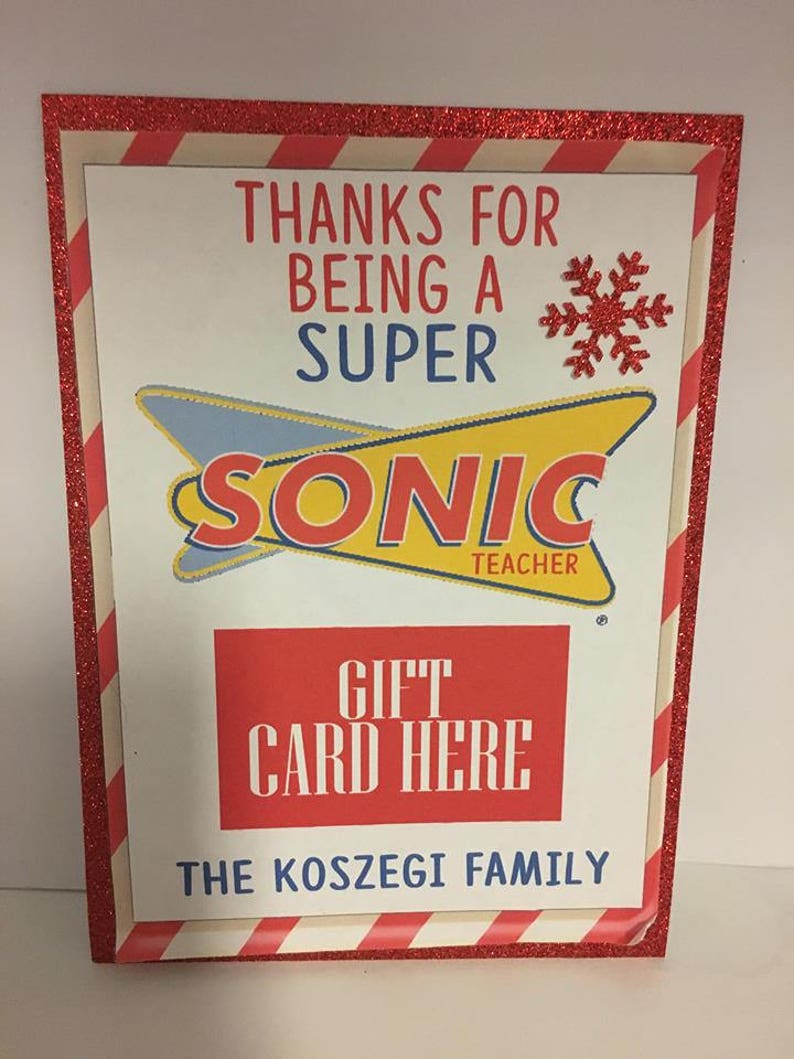 May include: A red and white striped card with a red glitter border. The card says "Thanks for being a super Sonic Teacher" with a red snowflake. There is a red rectangle with the words "Gift Card Here" and the text "The Koszegi Family" at the bottom.
