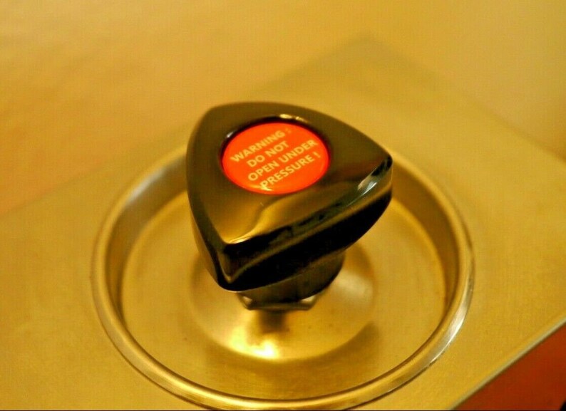May include: A black triangular knob with a red button that reads "WARNING DO NOT OPEN UNDER PRESSURE".