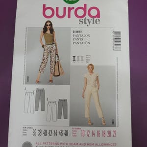 May include: A Burda Style 7068 sewing pattern envelope for pants. The front displays two variations of trousers, labeled A and B, shown on models. It includes size ranges from 36 to 48 in European sizes and 10 to 22 in US sizes, with text indicating seam and hem allowances are included.