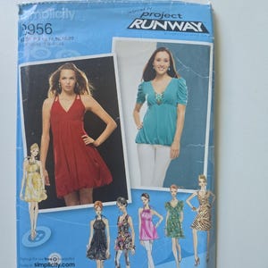 May include: A Simplicity 2956 sewing pattern envelope for Project Runway inspired tops and dresses. The packaging features photographs of a red bubble-hem dress and a teal V-neck top, along with illustrations of various garment styles in size P5.