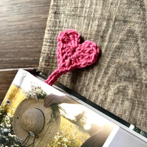 The finished bookmark, made from this crochet pattern, is peeking out the top of a book.