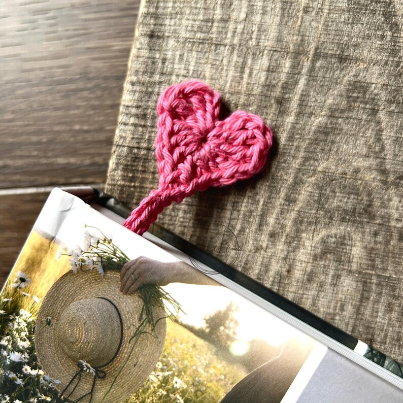 The finished bookmark, made from this crochet pattern, is peeking out the top of a book.