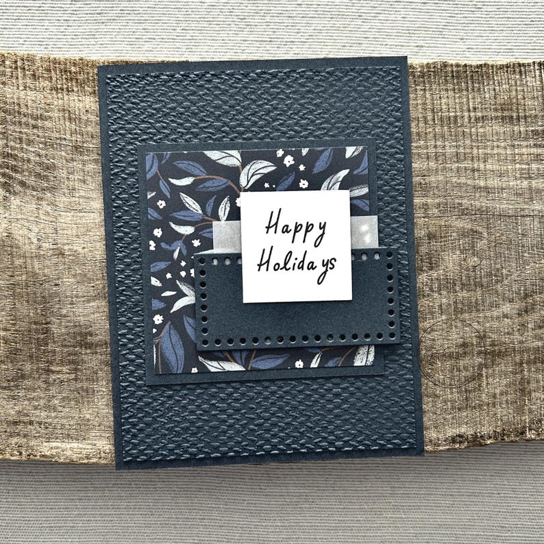 A finished card, from this card making kit, sitting on a wooden board.