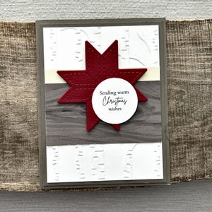 A finished card, from this card making kit, sitting on a wooden board.