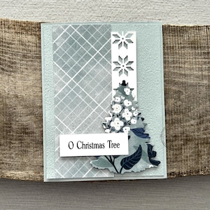 A finished card, from this card making kit, sitting on a wooden board.