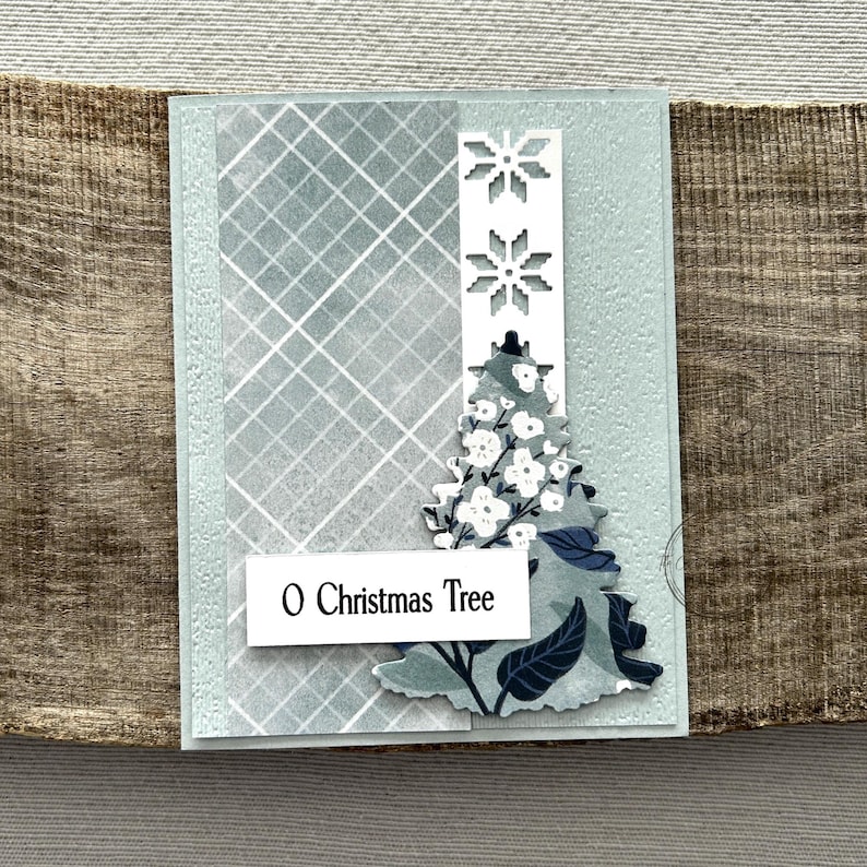 A finished card, from this card making kit, sitting on a wooden board.