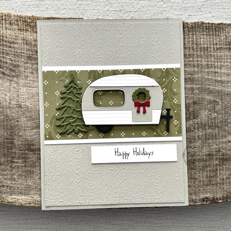 A finished card, from this card making kit, sitting on a wooden board.