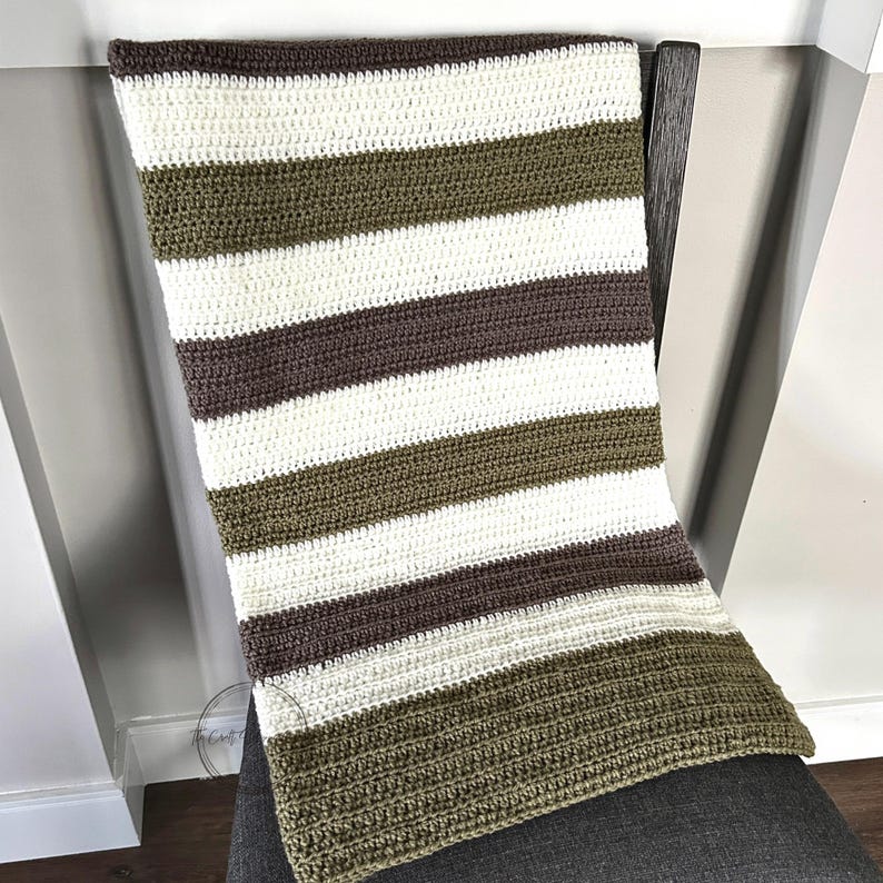 The finished blanket, made from this crochet pattern, is lying over a chair.