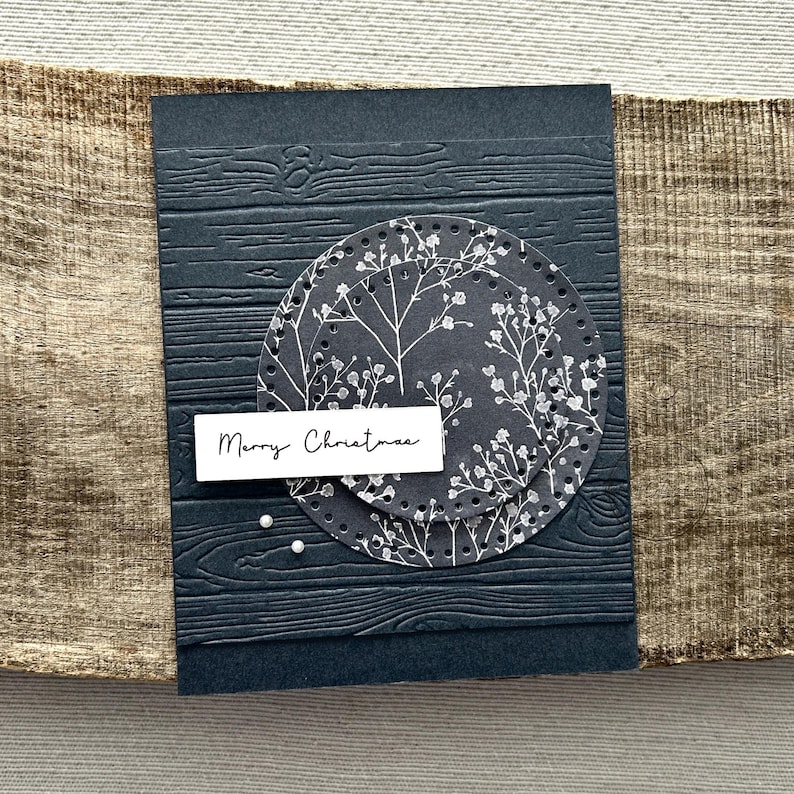 A finished card, from this card making kit, sitting on a wooden board.