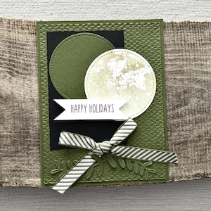 A finished card, from this card making kit, sitting on a wooden board.