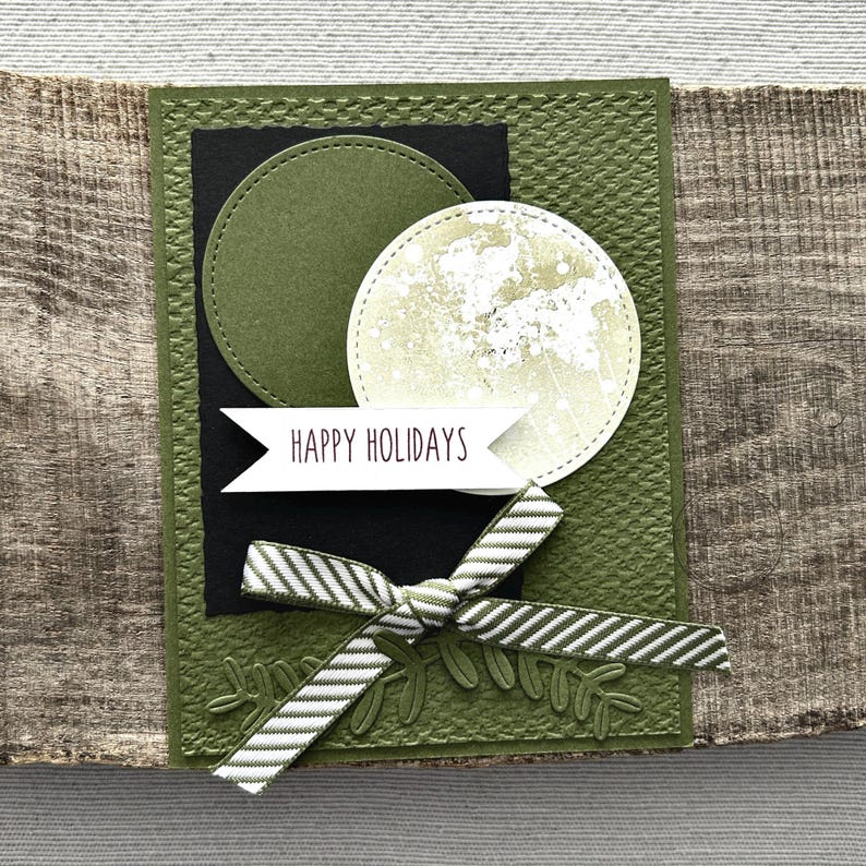 A finished card, from this card making kit, sitting on a wooden board.