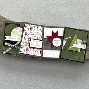 There are 4 finished cards, sitting on a wooden board, to show the finished cards that are included in this card making kit.