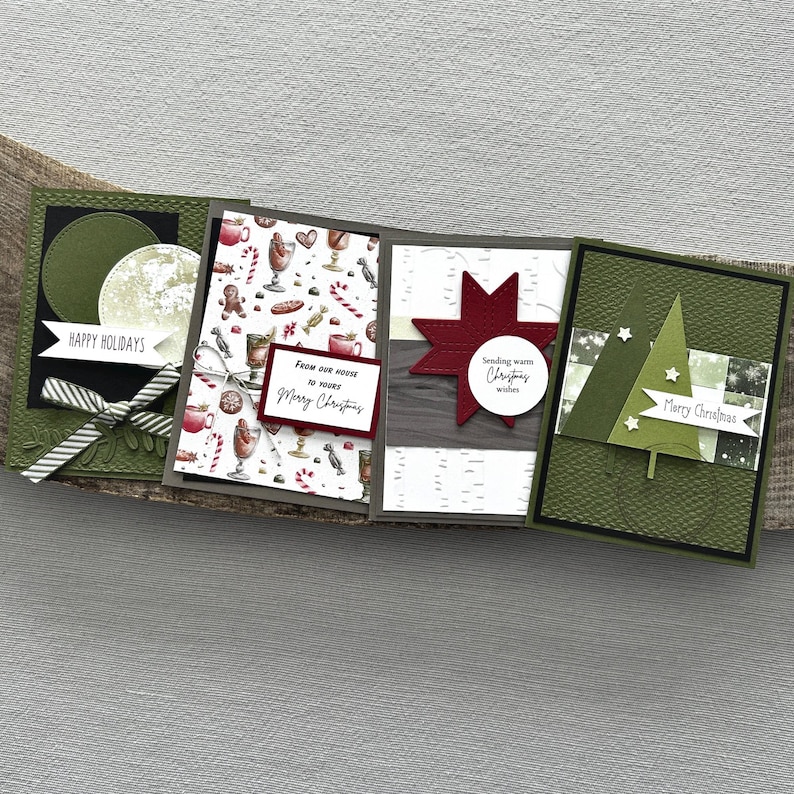 There are 4 finished cards, sitting on a wooden board, to show the finished cards that are included in this card making kit.