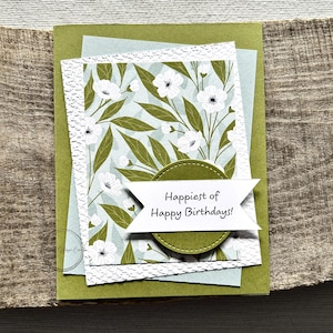 A finished card, from this card making kit, sitting on a wooden board.