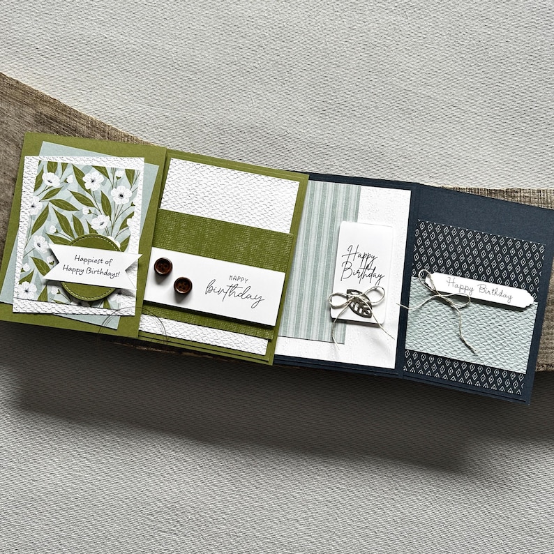 There are 4 finished cards, sitting on a wooden board, to show the finished cards that are included in this card making kit.
