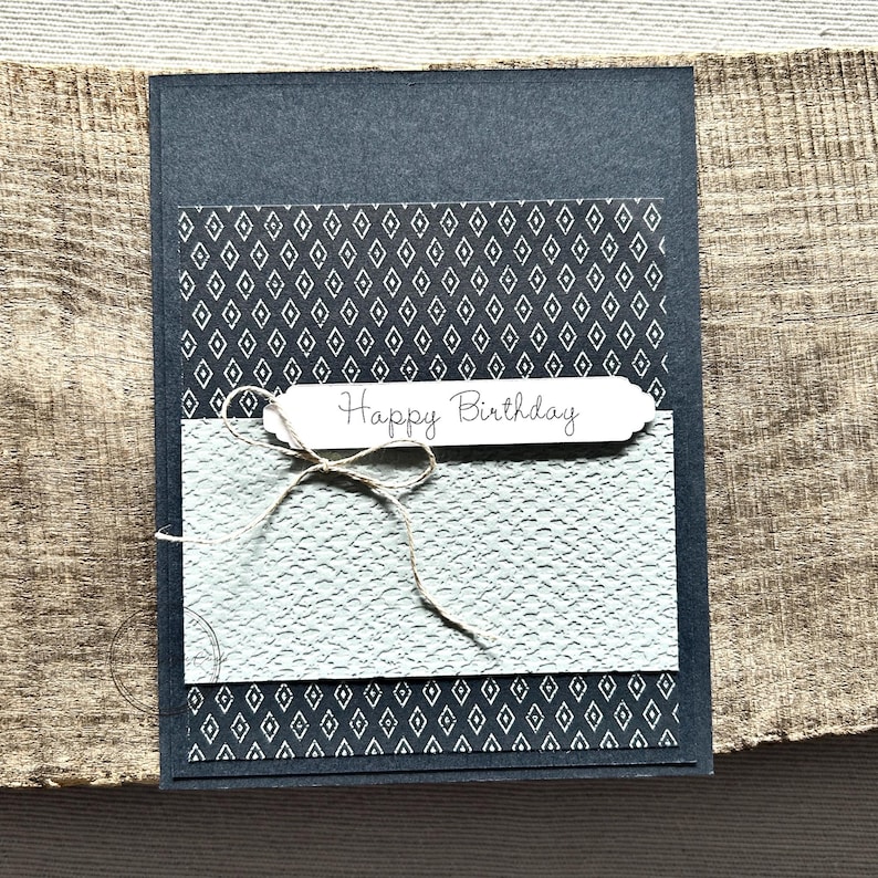 A finished card, from this card making kit, sitting on a wooden board.