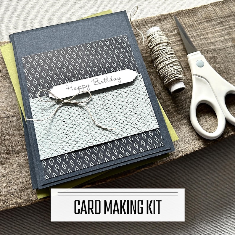 A DIY card making kit for Birthday cards. A finished card is sitting on blank cards with a roll of twine and scissors.