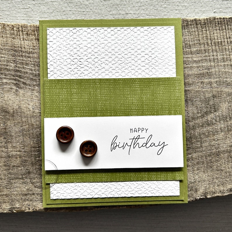 A finished card, from this card making kit, sitting on a wooden board.