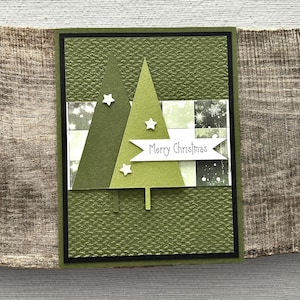 A finished card, from this card making kit, sitting on a wooden board.