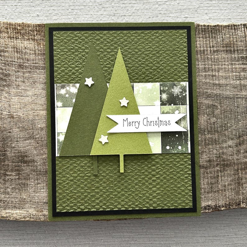 A finished card, from this card making kit, sitting on a wooden board.