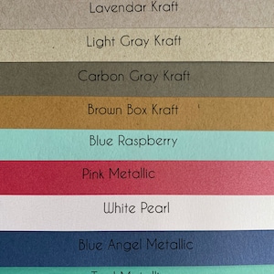 May include: An image showing a selection of eleven paper swatches in various colours. The swatches are labelled with their names, including "White Kraft", "Pink Metallic", and "Blue Angel Metallic". The palette includes shades of white, grey, brown, blue, pink, and purple.