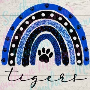 Puede incluir: Un arcoíris azul, negro y blanco con una huella de pata en el centro. El arcoíris tiene un patrón de lunares blancos, un patrón moteado azul y blanco y un patrón de leopardo azul. El texto "tigers" está escrito debajo del arcoíris.