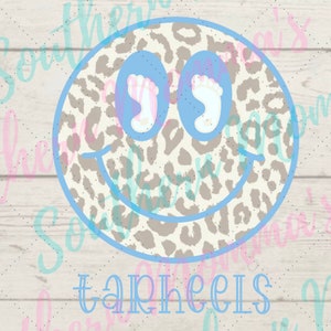 May include: A blue and white smiley face with a leopard print background. The eyes are baby footprints. The text "Tar Heels" is below the smiley face.