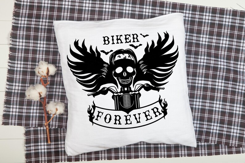 May include: White pillow with a black graphic of a skull riding a motorcycle with wings and the text "Biker Forever".
