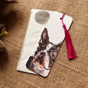 A bookmark showcasing a design from one of Alex's original paintings, featuring a Boston Terrier design. Printed on fine Italian card, it comes with a hot pink coloured tassel color, packaged in a glassine bag, and finished with a stylish branded sticker.