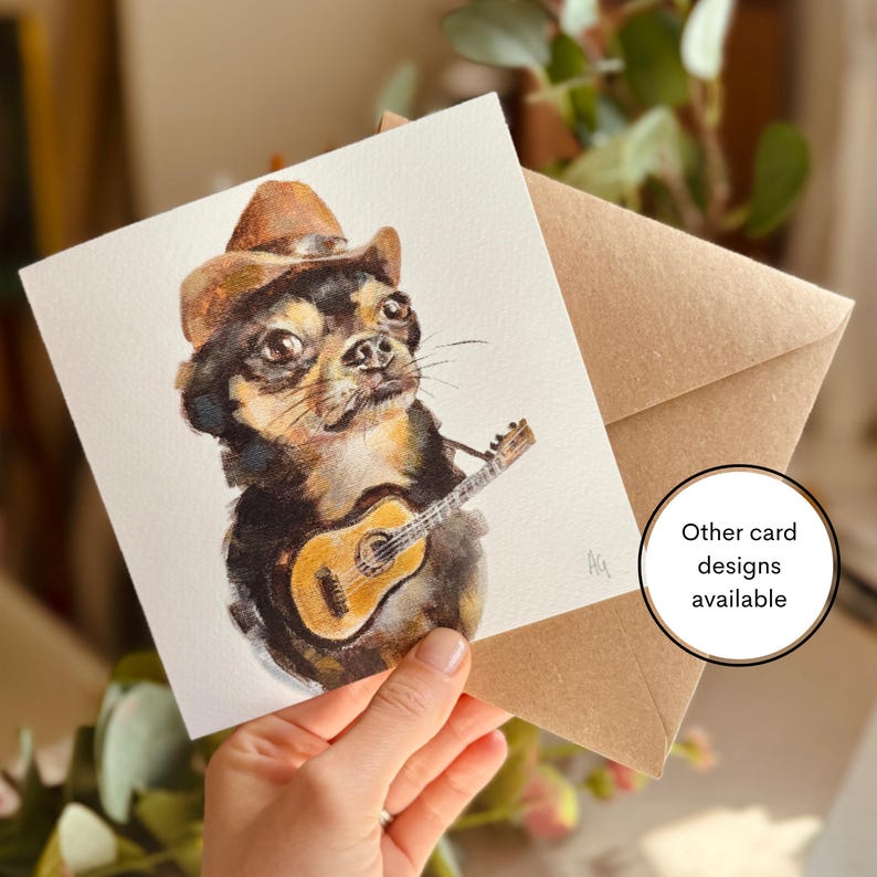 A greeting card featuring a design from one of Alex's original paintings, illustrated with a whimsical design of a Chihuahua with a guitar and cowboy hat. Printed on 250gsm Tintoretto Gesso paper, it comes with a brown kraft envelope and is packaged in a compostable sleeve.