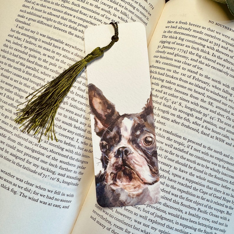 A bookmark showcasing a design from one of Alex's original paintings, featuring a Boston Terrier design. Printed on fine Italian card, it comes with an army green coloured tassel color, packaged in a glassine bag, and finished with a stylish branded sticker.