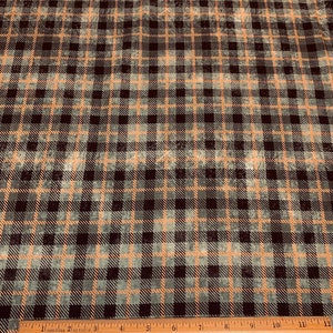 May include: Close-up of a fabric with a plaid pattern. The design features a grid of black, gray, and orange intersecting lines. A wooden ruler with inch markings is at the bottom. The text "PWTH152 Foreboding" is visible.