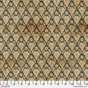 May include: Close-up of a fabric with a repeating black lace pattern over a tan background. The lace design features floral and geometric shapes. The fabric has a vintage, aged appearance, with subtle brown spots. The image includes a ruler with inch measurements.
