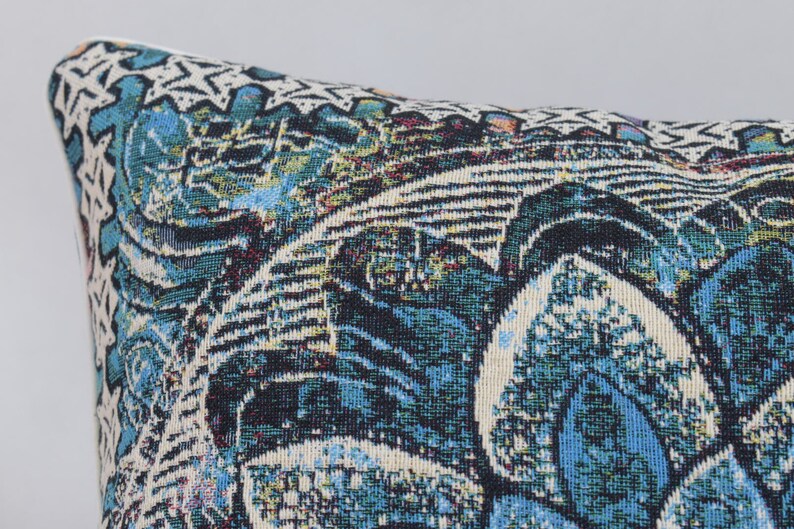 Puede incluir: Una almohada de tiro azul, verde y blanca con un dise&ntilde;o floral.