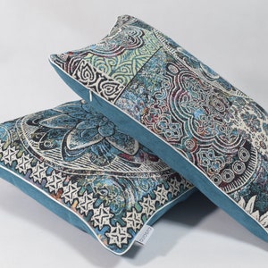 Puede incluir: Dos almohadas decorativas con un patr&oacute;n paisley azul y blanco. Las almohadas tienen un borde azul turquesa y una cremallera blanca.