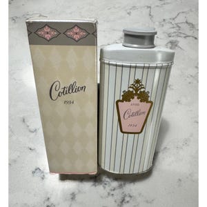May include: Vintage Avon Cotillion powder container and box. The container is white with vertical stripes and a pink and gold label. The box is beige with a diamond pattern and the Cotillion logo.