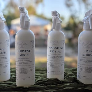 May include: Four white plastic spray bottles labeled Boss Custom Creations, featuring scents Skin of a Killer, Harvest Moon, Moonstone Crystal, and Dark Storms. Each bottle includes a white trigger sprayer and a detailed product label.