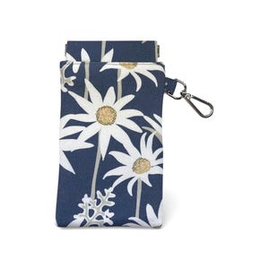 May include: A navy blue floral print phone case with a silver-colored clasp. The case features a white daisy pattern with yellow centers and gray leaves. The case is rectangular and has a small pocket on the top.