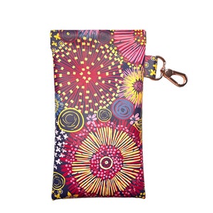 May include: A red, yellow and blue patterned pouch with a gold zipper and a gold hook. The pouch is made of a soft, durable material and is ideal for carrying small items.