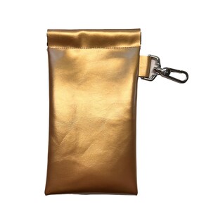 May include: A gold-colored leather pouch with a silver clip. The pouch has a fold-over top and a smooth, shiny finish.