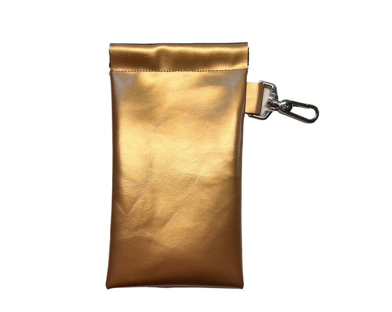 May include: A gold-colored leather pouch with a silver clip. The pouch has a fold-over top and a smooth, shiny finish.