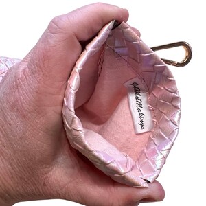 May include: A pink woven pouch with a gold clasp and a white label that says "JoMezMakings".