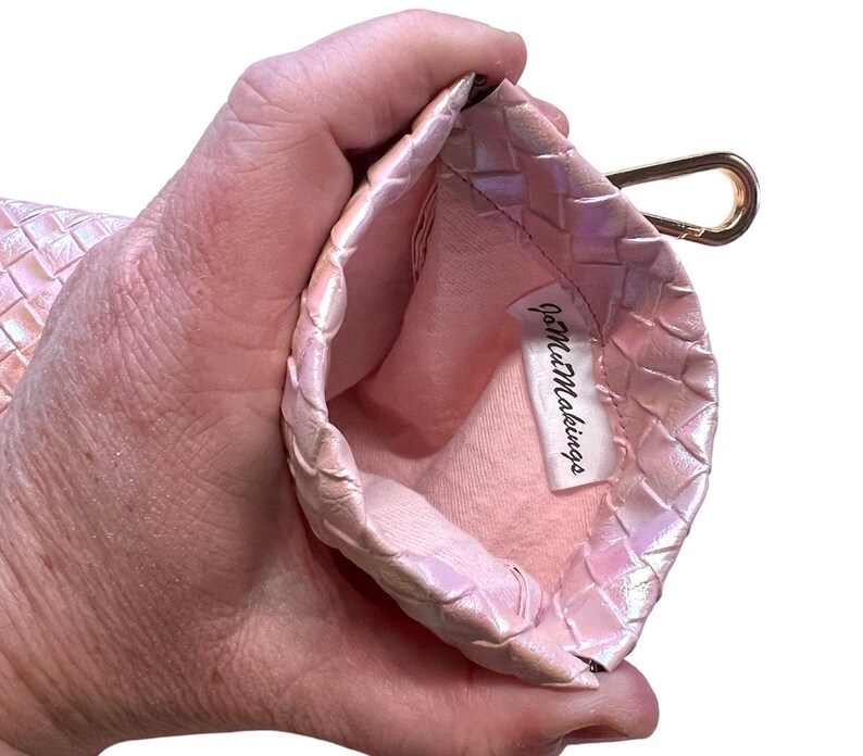 May include: A pink woven pouch with a gold clasp and a white label that says "JoMezMakings".