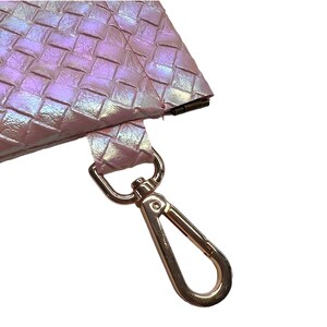 May include: A pink iridescent woven purse with a gold metal clasp and a gold metal hook.
