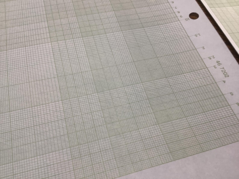 May include: A close-up of a sheet of graph paper with a light green grid pattern on a white background. The paper has a series of numbers and a hole punch on the right side. The text "46 7202" is visible.