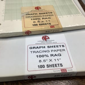 May include: Two stacks of graph paper. The top stack is drawing paper, 8.5 x 11 inches, 100% rag, and contains 100 sheets. The bottom stack is tracing paper, 8.5 x 11 inches, 100% rag, and contains 100 sheets. Both stacks have labels with the brand logo.