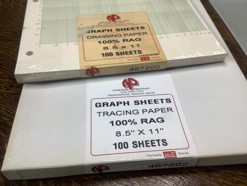 May include: Two stacks of graph paper. The top stack is drawing paper, 8.5 x 11 inches, 100% rag, and contains 100 sheets. The bottom stack is tracing paper, 8.5 x 11 inches, 100% rag, and contains 100 sheets. Both stacks have labels with the brand logo.