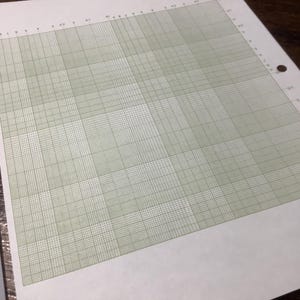 May include: A sheet of graph paper with a grid of light green lines on a white background. The paper has evenly spaced horizontal and vertical lines, creating a series of small squares. The paper has holes on the left side for binding.