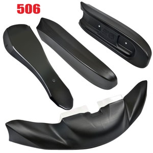 May include: A set of four black plastic car body parts. The parts are designed to be used as a spoiler, side skirts, and a rear diffuser. The parts are labeled with the number "506".
