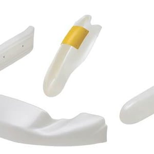 May include: An assortment of white plastic components, possibly for a larger product. One piece has a yellow adhesive strip. The shapes vary, including curved and rectangular forms. The objects are isolated against a white background.